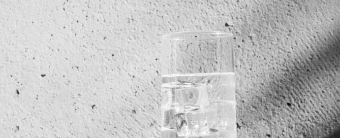 glass of ice water against wall