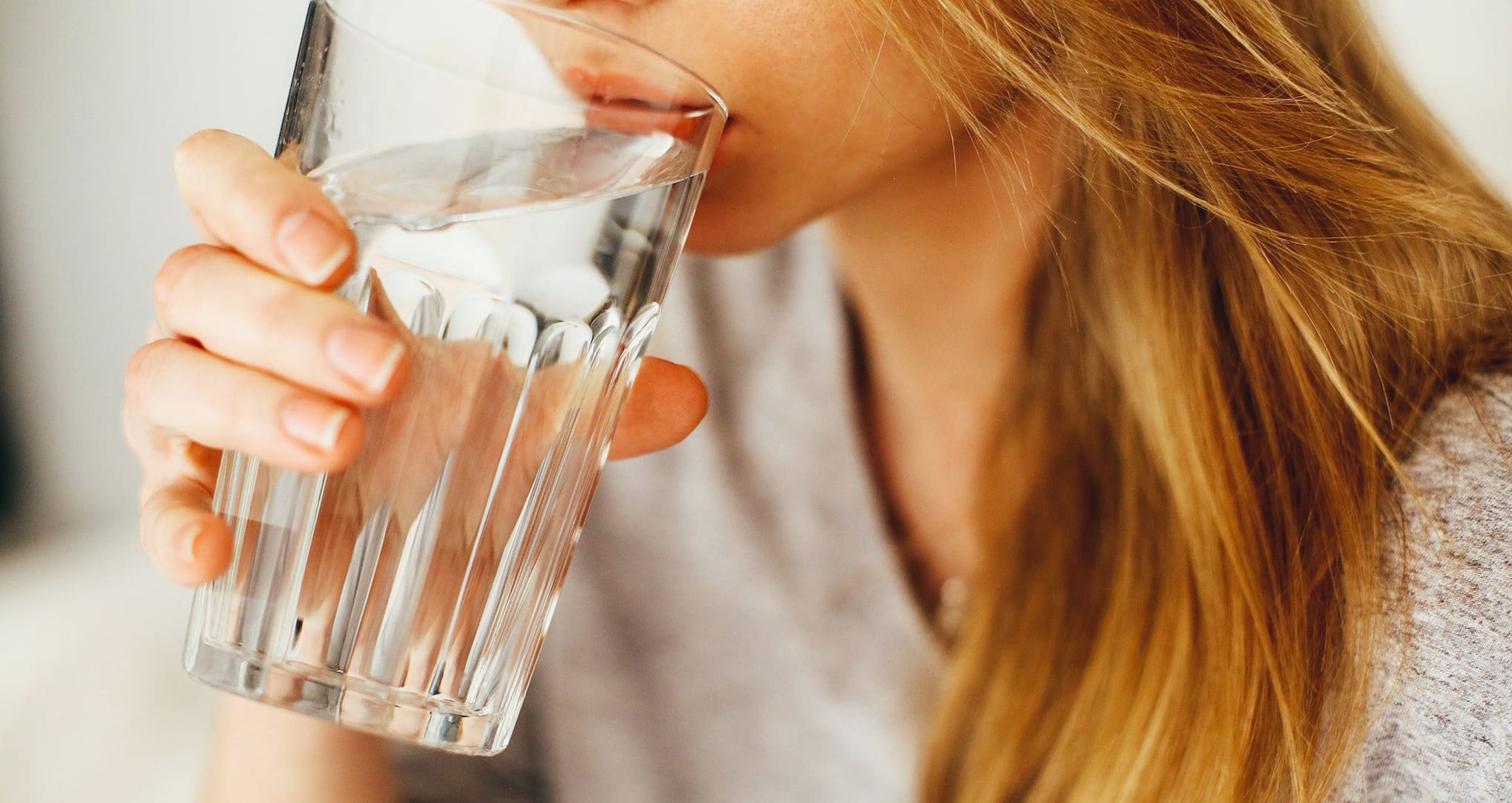 what-are-the-health-benefits-of-water woman drinking water from glass