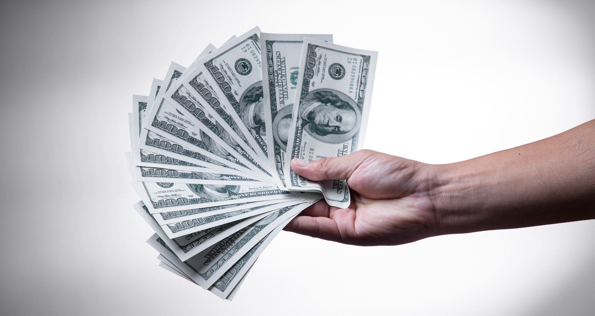 hand holding money fanned out
