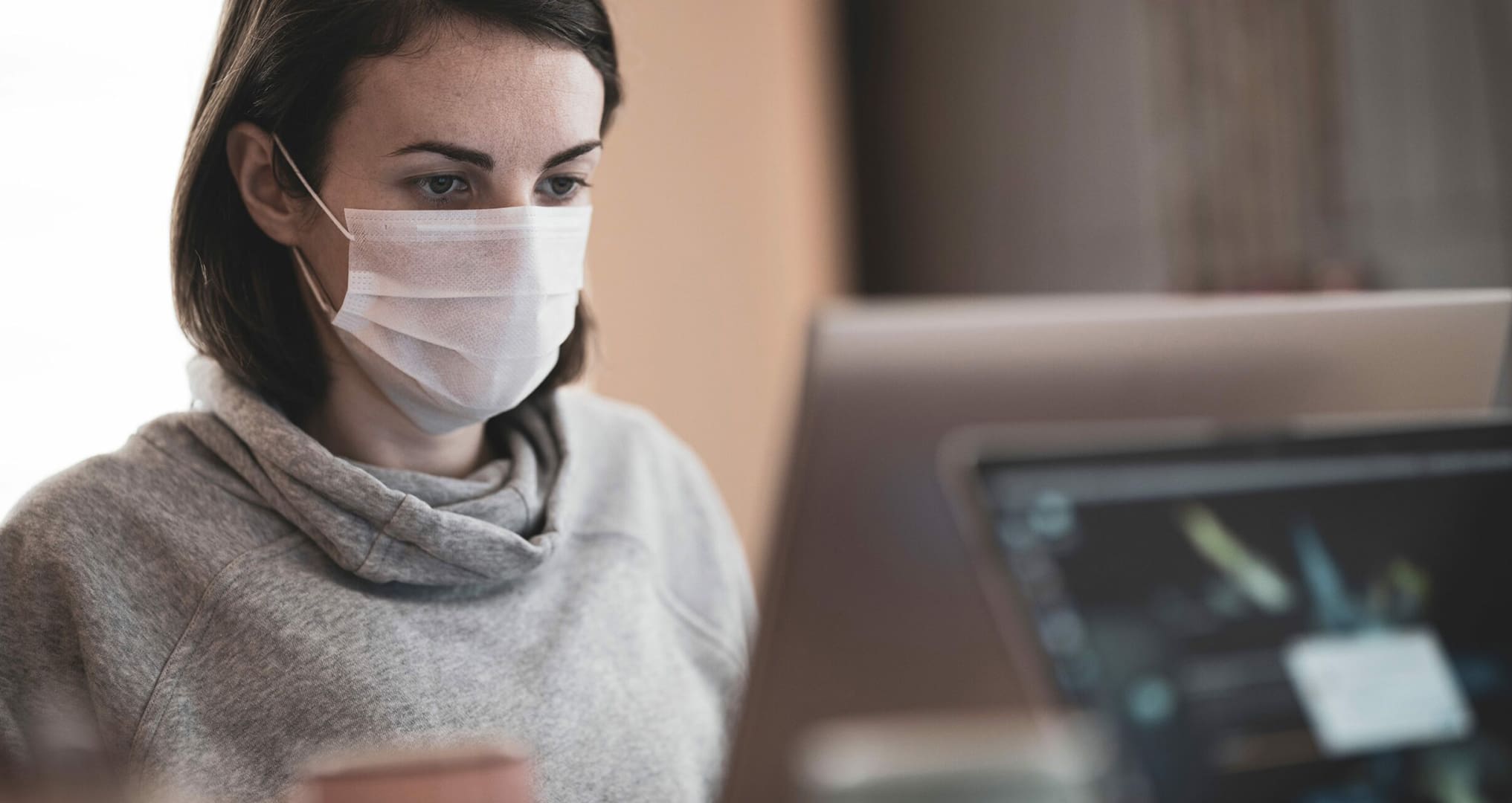 woman wearing mask at computer desk