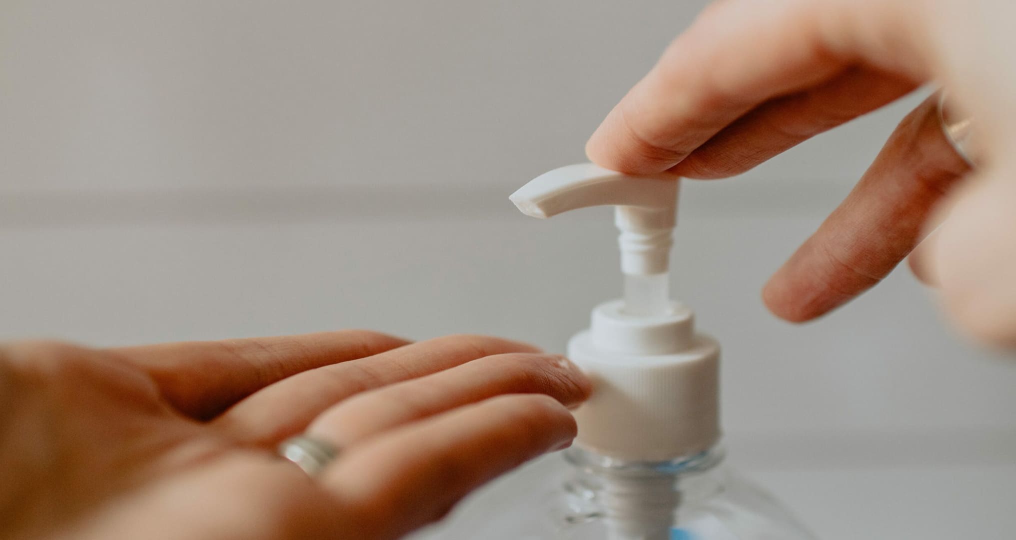 person pumping hand santizer on hands