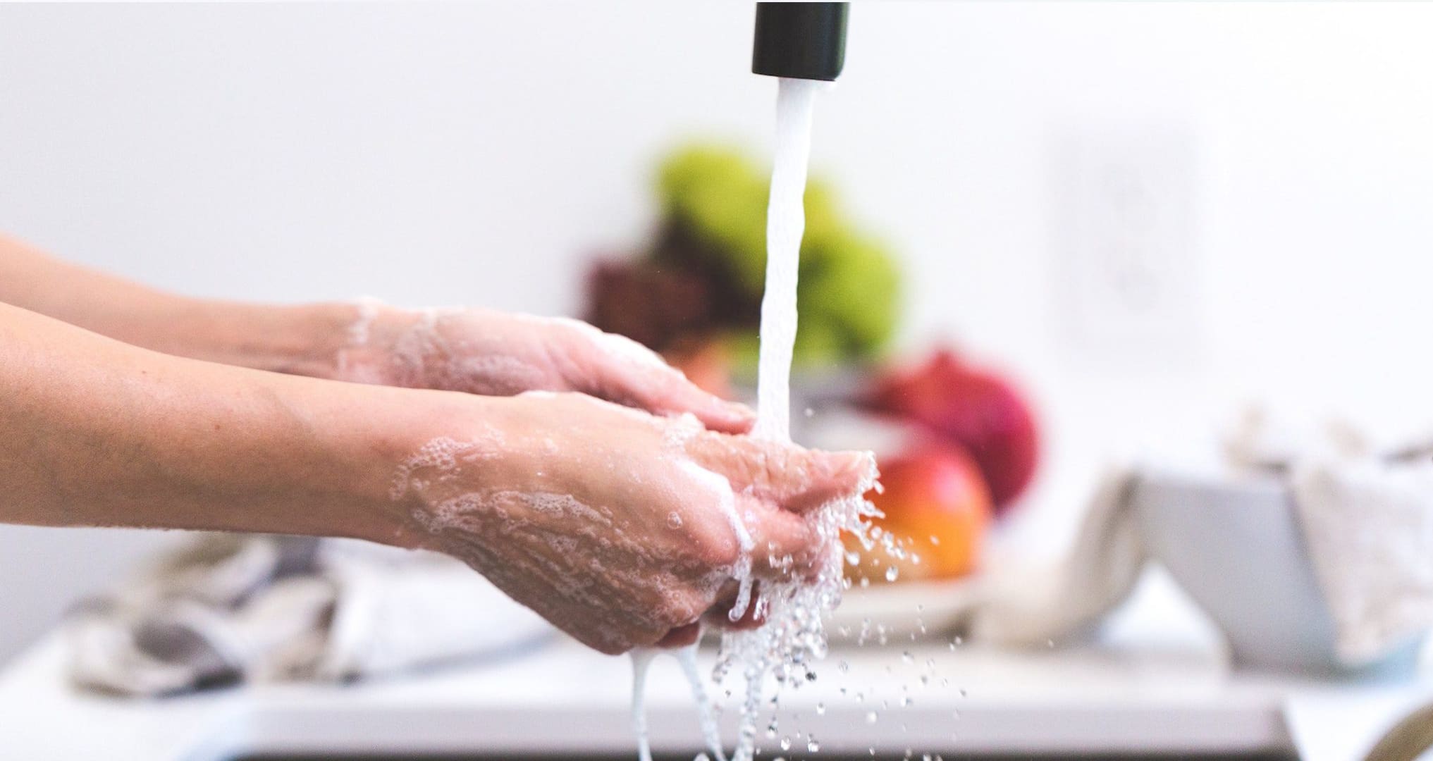 person washing hands in kitchen