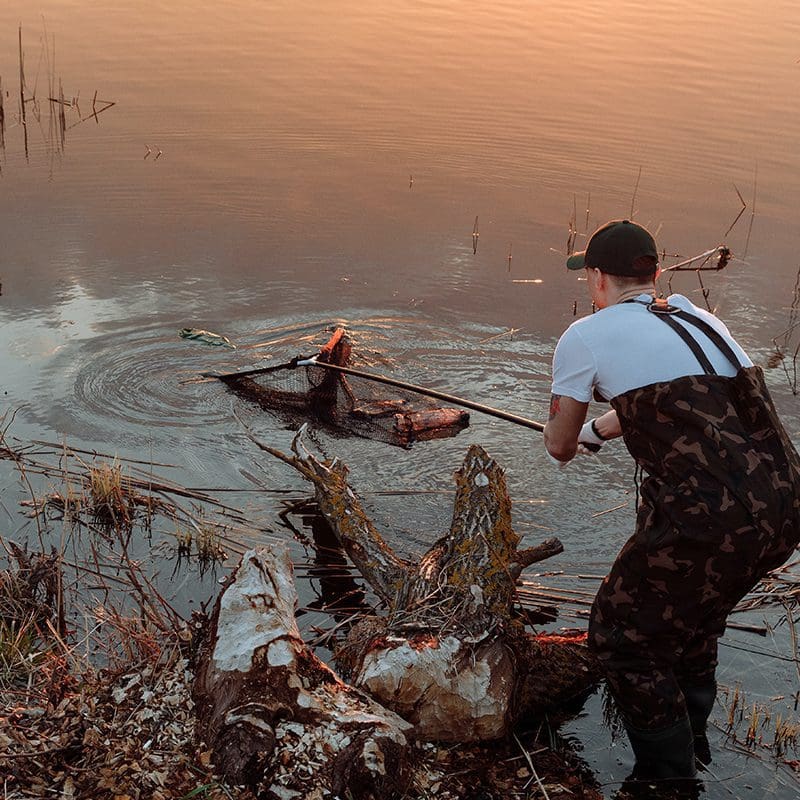 man cleaning out portion of lake man cleaning out portion of lake