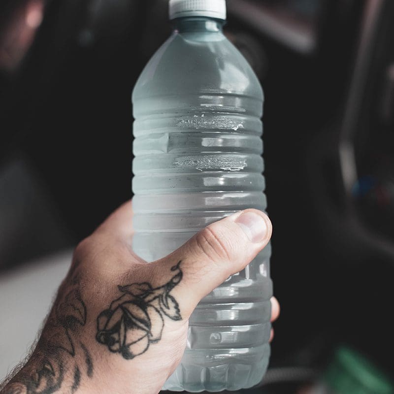 man holding a bottled water Bottled water image