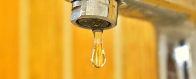 dripping faucet in yellow bathroom