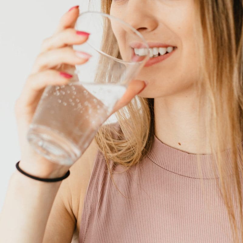 woman drinking a glass of water woman drinking a glass