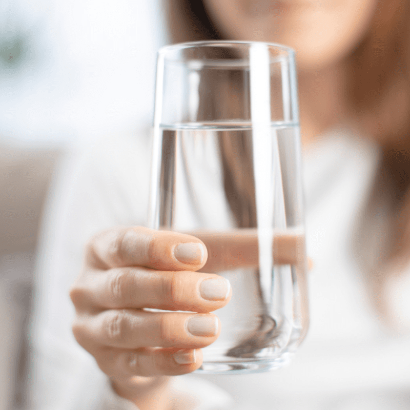 employee holds a glass of plain water
