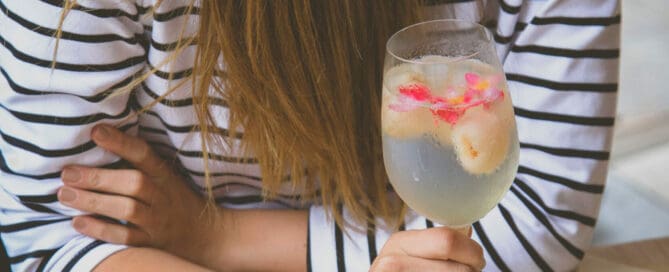 woman holding glass of sparkling water with fruit