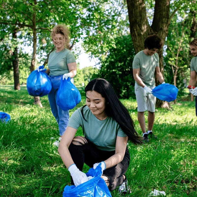 young woman with garbage bag cleaning environment