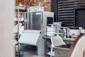 Clean outside restaraunt kitchen full of dishes ice machine in kitchen