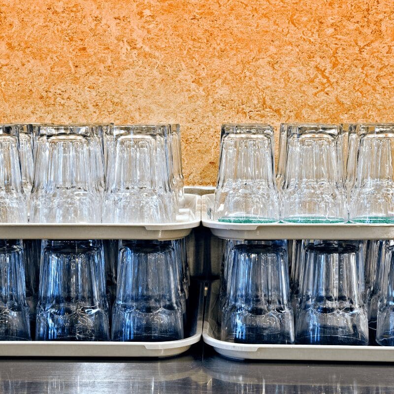 stacked-glasses-in-a-cafeteria reusable glassware in the office breakroom